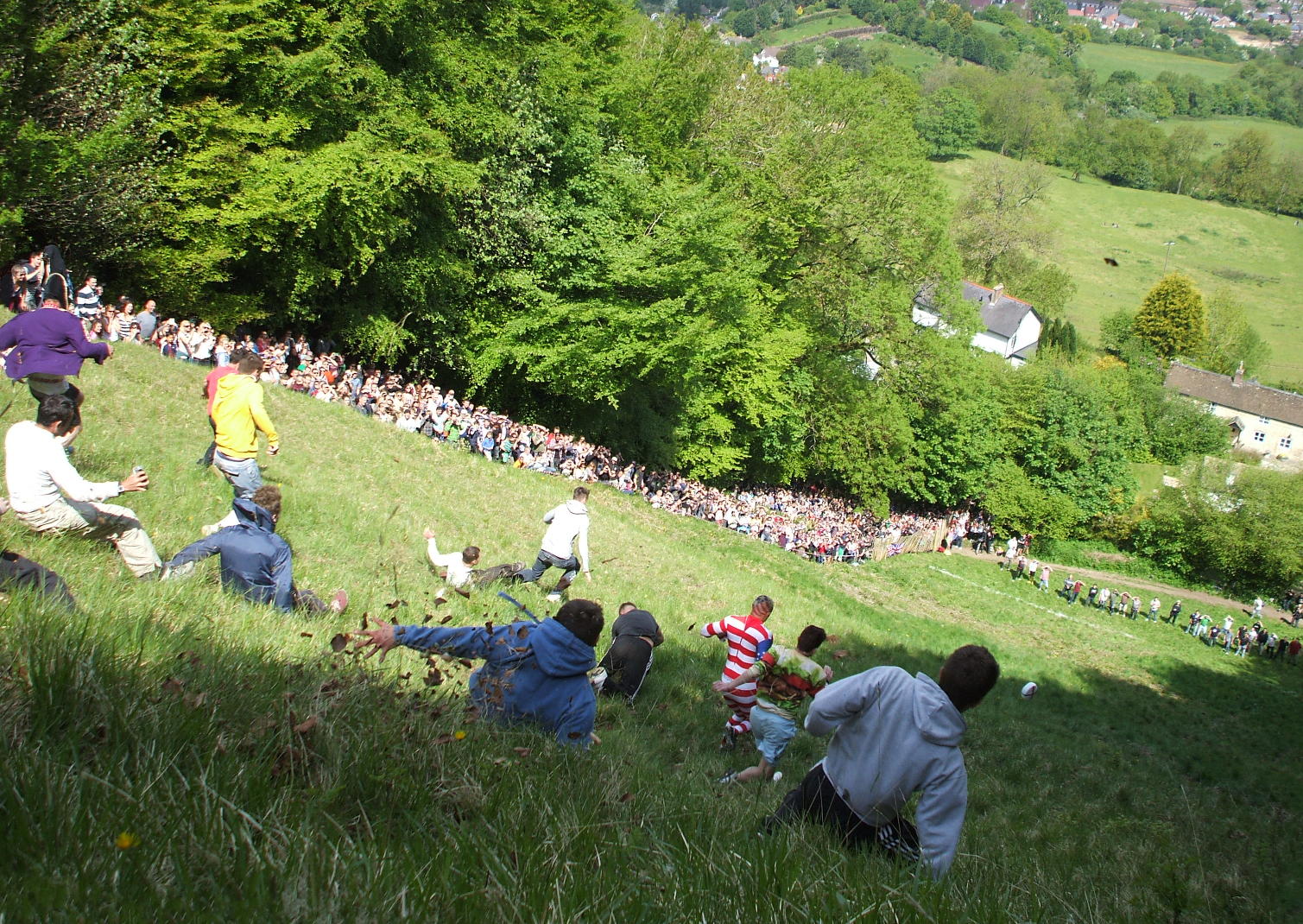 fiestas del mundo Participantes corriendo detrás del queso en el festival de Cooper's Hill.